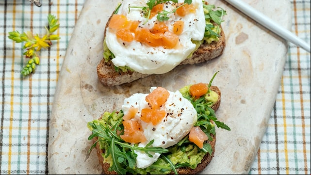 Tosta aguacate, salmón y lechuga con una taza de café