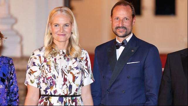Mette-Marit y Haakon de Noruega con vestido blanco estampado y traje azul marino