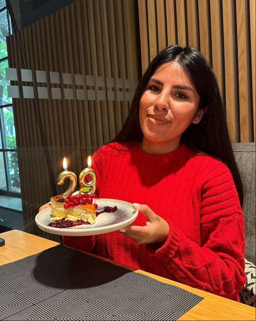 Plano medio de Isa Pantoja posando con su tarta de cumpleaños con velas