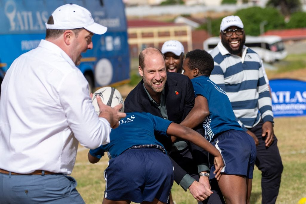 Plano medio del Principe Guillermo jugando con niños en su visita a Sudáfrica
