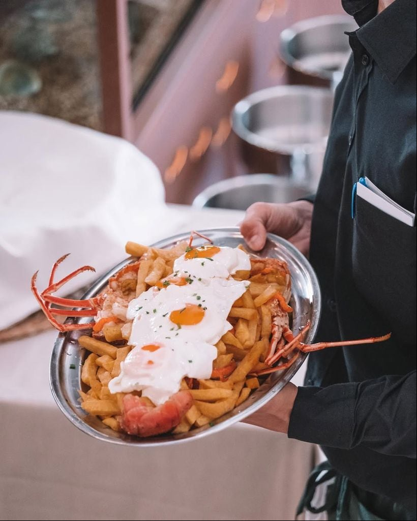 Huevos fritos con langosta y patatas