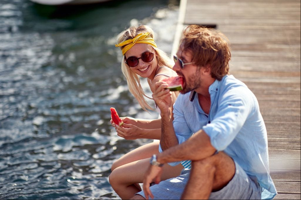 pareja comiendo sandía en el muelle