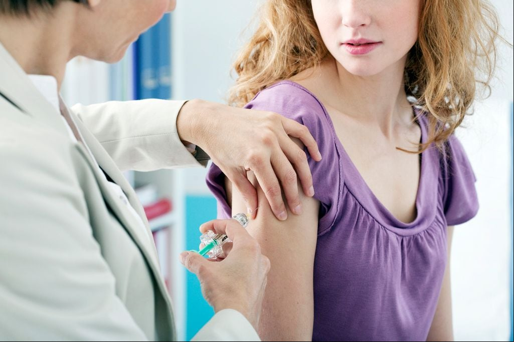 mujer joven poniéndose la vacuna del virus del papiloma humano (VPH)